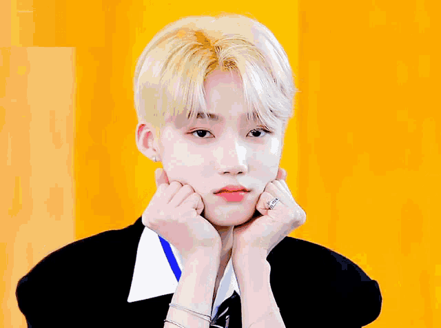 a young man with his eyes closed and his hands on his face