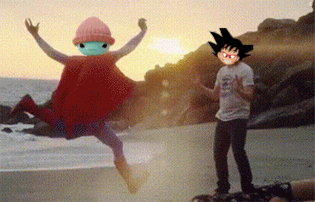 a man in a white shirt stands next to a man in a red cape on a beach
