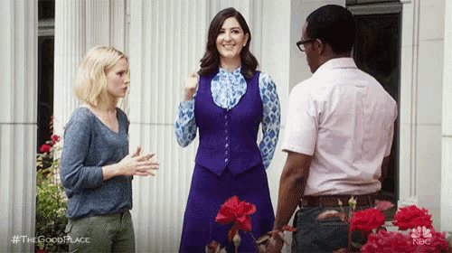 a man and two women are standing next to each other in front of a building .