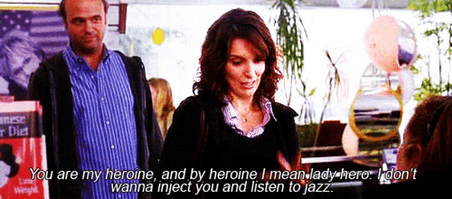 a man and a woman are standing next to each other and the woman says you are my heroine