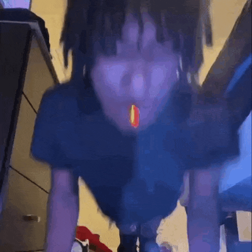 a person with dreadlocks is standing in a room .