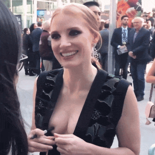 a woman with a plunging neckline is smiling while talking to another woman