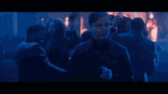 a man is standing in the middle of a crowd of people .