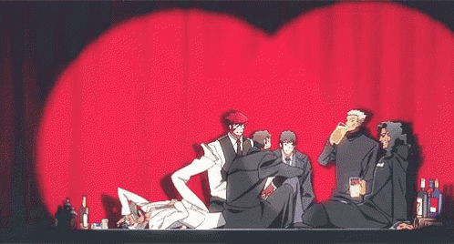 a group of people are sitting in front of a red curtain and toasting with glasses .
