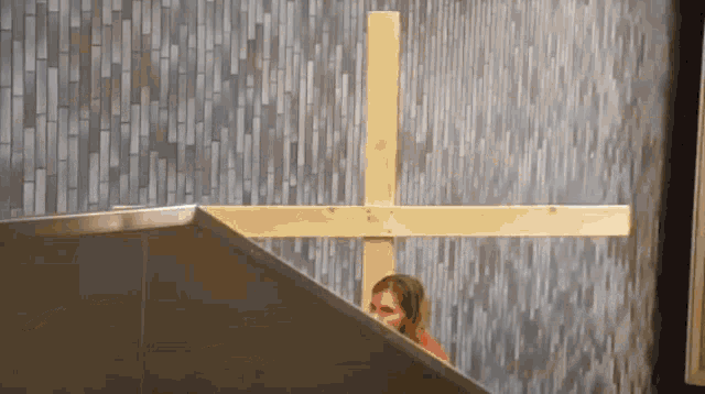 a wooden cross is against a tiled wall in a church