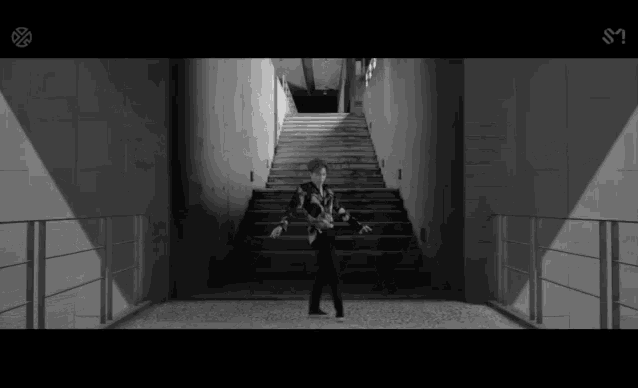 a black and white photo of a man standing in a hallway