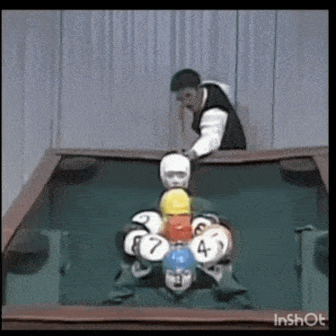 a man is playing pool with balls that have the numbers 1 through 7 on them
