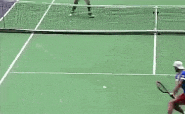 a man in a red shirt is swinging a tennis racket
