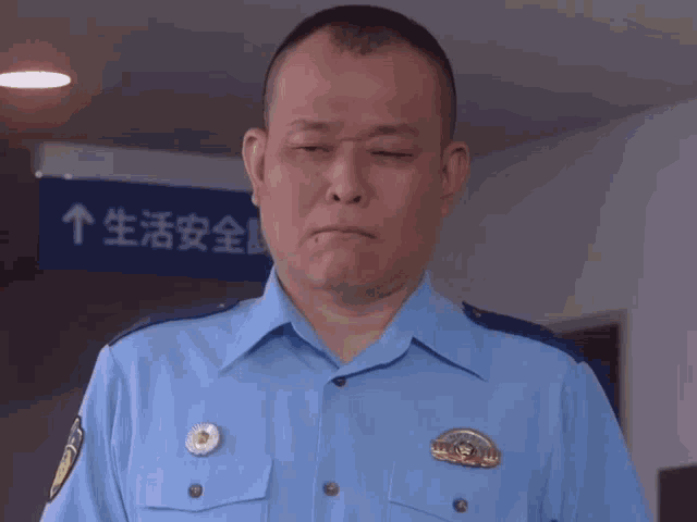 a man in a police uniform stands in front of a blue sign with chinese characters