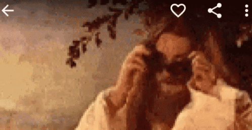 a pixelated image of a woman wearing sunglasses and a white coat