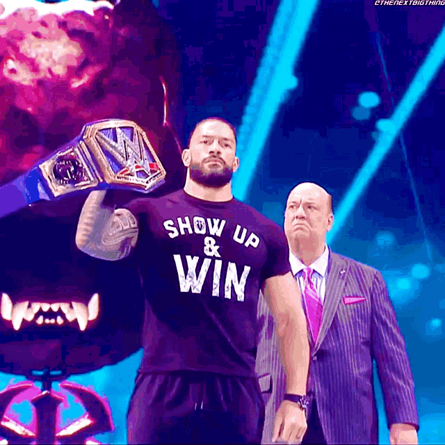 a man in a show up and win shirt is holding a wrestling championship belt