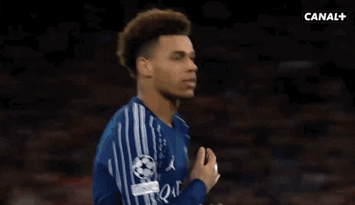 a soccer player in a blue jersey is being bumped by another player in a blue jersey .