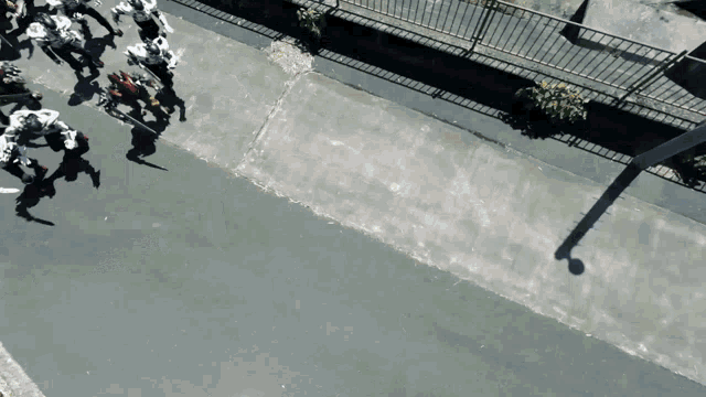 a group of people walking down a street with their shadows on the ground