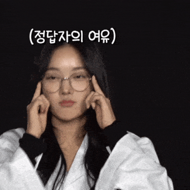 a woman wearing glasses and a white jacket is making a funny face in korean
