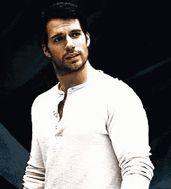 a man with a beard is wearing a white shirt and talking to someone .