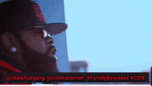 a man with a beard wearing a hat and a red sign that says family business