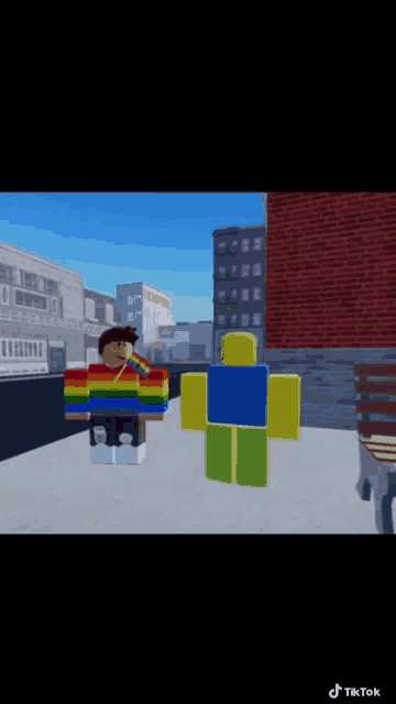 a boy in a rainbow sweater is standing next to a roblox character