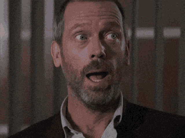a man with a beard is making a surprised face with his mouth wide open