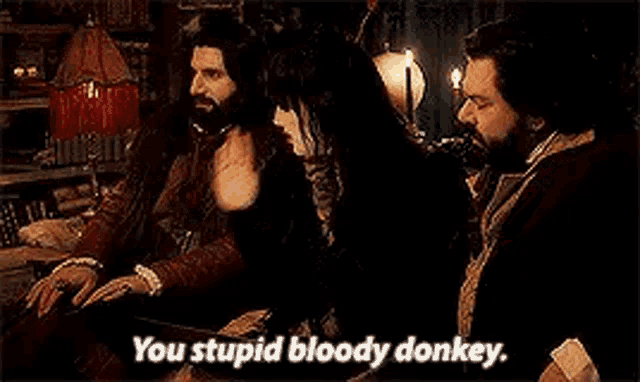 a man in a vampire costume is talking to a woman in a room .