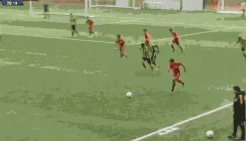 a group of soccer players are playing a game on a field . one of the players has the number 4 on his shirt .