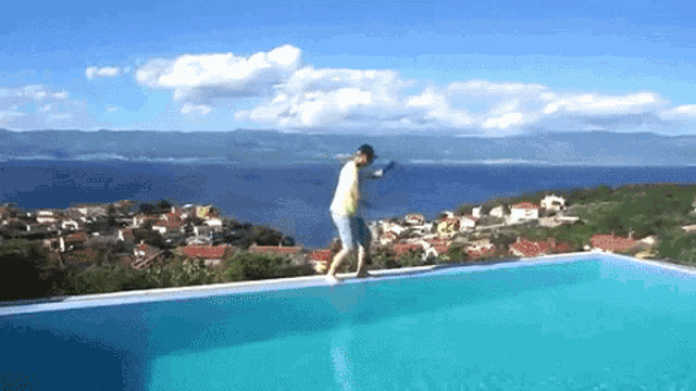 a man standing on the edge of an infinity pool