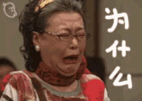 a woman wearing glasses and a scarf is crying with chinese writing on her face .