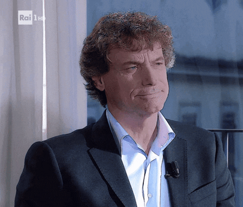 a man in a suit and a blue shirt is on a rai 1 channel