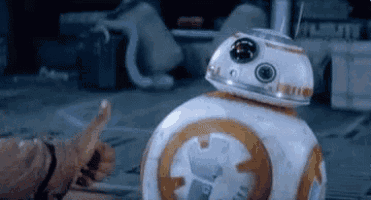 a person is giving a thumbs up to bb-8 , the robot from star wars .