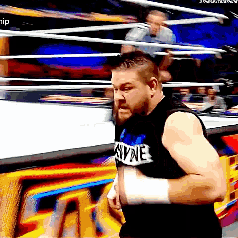 a man in a wrestling ring is wearing a shirt that says ' anyone ' on it