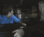 a man in a blue shirt is talking to a woman in a black shirt
