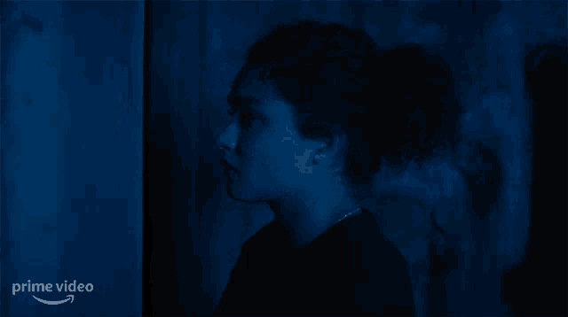 a woman in a dark room with the word prime video on the bottom right
