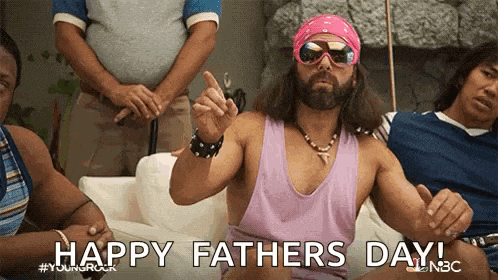 a man in a pink tank top and sunglasses is sitting on a couch with other men .