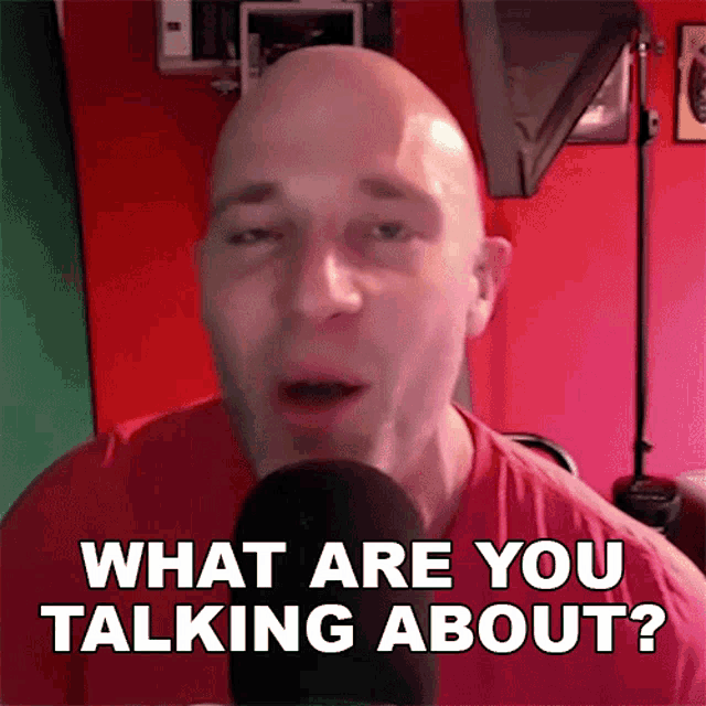 a bald man is talking into a microphone with the words what are you talking about