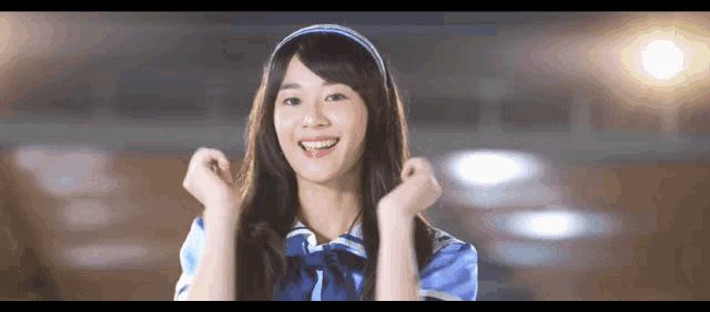 a girl with long hair wearing a blue shirt and a headband