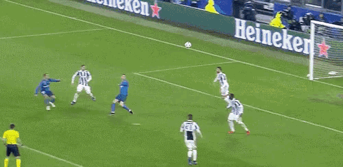 a soccer goalie jumps to catch a ball in front of a sign that says 7