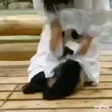 a person in a white robe is sitting on a wooden floor