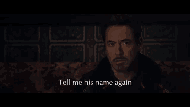 a man sitting on a couch with the words tell me his name again