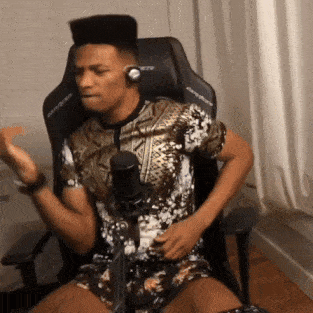 a man wearing headphones is sitting in a chair in front of a microphone ..