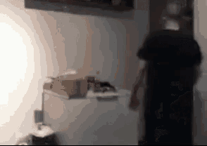 a blurry picture of a man standing next to a freezer .