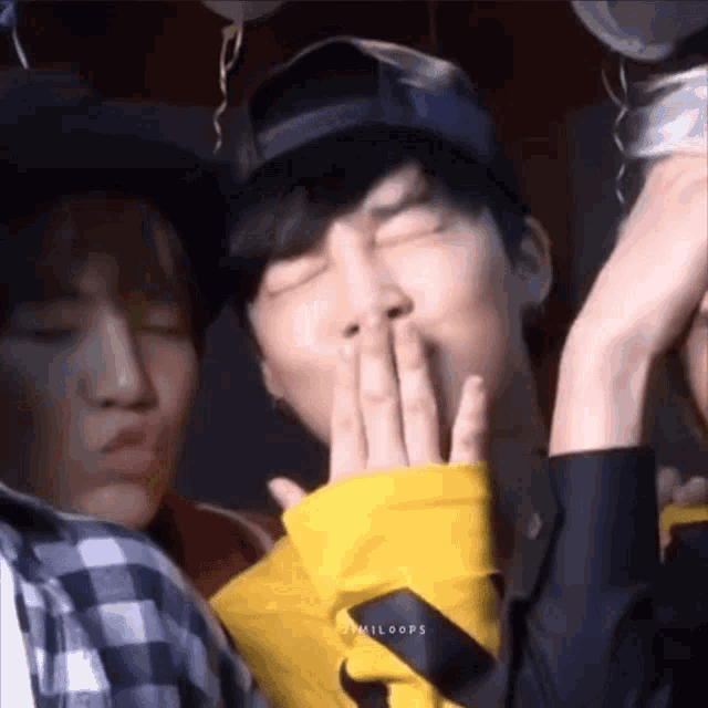 a close up of a person covering their mouth with their hand