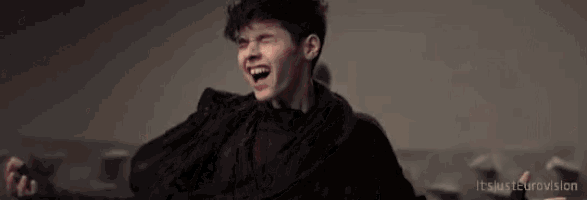 a young man is laughing with the words " it 's just eurovision " on the bottom