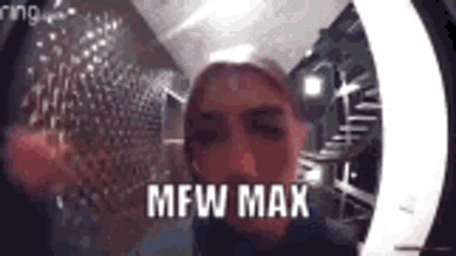 a man is standing in front of a ring doorbell and the words mfw max are on the screen .