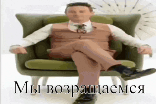 a man in a suit and tie is sitting in a chair with the words " мы возращаемся " written on the bottom