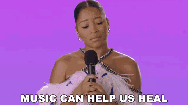 a woman singing into a microphone with the words music can help us heal above her