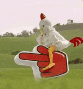 a stuffed chicken is riding on the back of a red finger .
