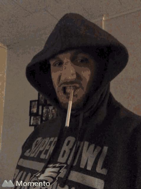 a man with a cigarette in his mouth wears a super bowl shirt