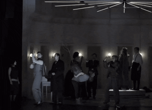 a group of people in a dark room including a man carrying another man