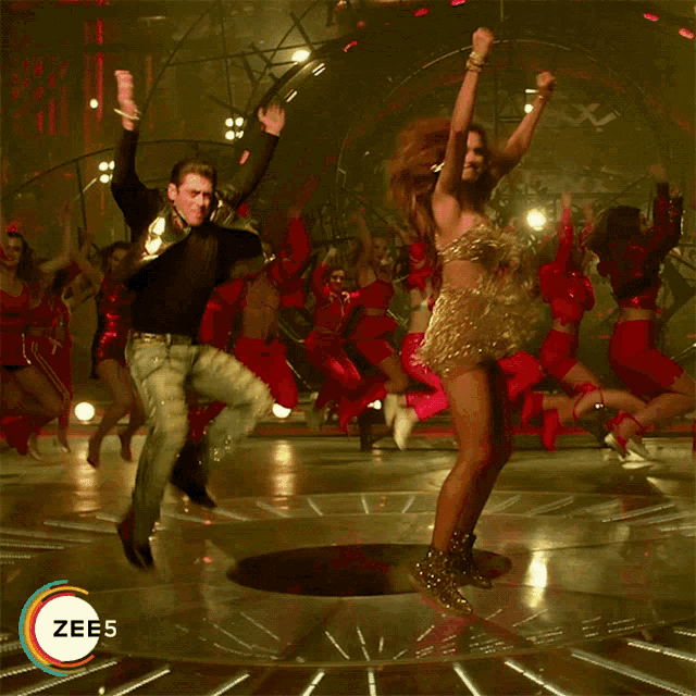 a man and a woman are dancing on a stage with the word zee5 on the bottom left