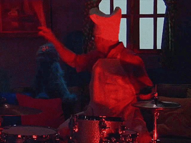 a man wearing a chef hat is playing drums