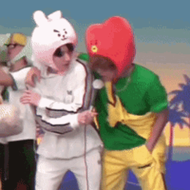 a man in a green shirt is talking into a microphone while wearing a bunny hat .